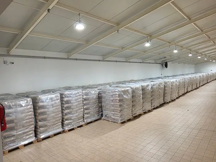 Jasna hala magazynu z rzędem palet pelletu