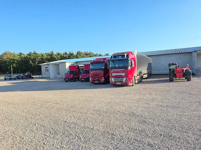 Samochody firmy i hala magazynu w popołudniowym słońcu
